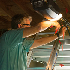 Technician repairing garage door mechanism in Burlington.