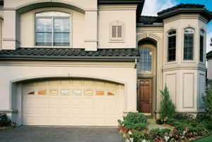 Steel garage doors on a large white home.