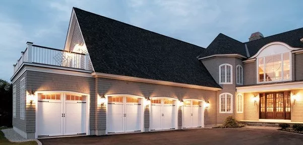 Four white garage doors at a large home in Vermont.