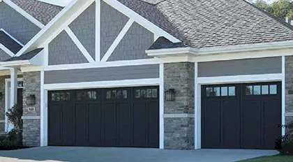 Gray home with large black garage door with windows