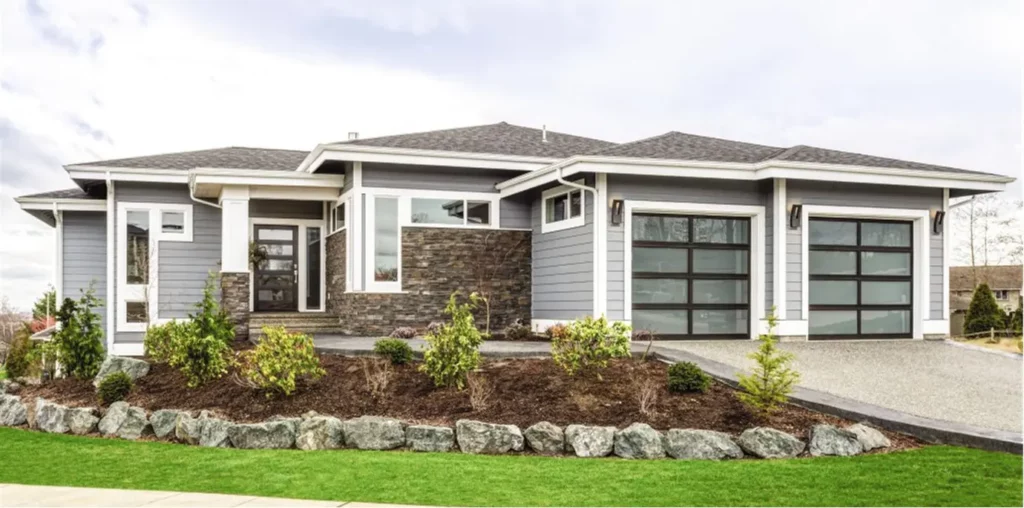 Modern garage door on a residential home. The garage door is aluminum, with glass panels.